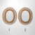 A wall mirror from the 1950s characterised by an oval rattan frame composed of a succession of curved elements radiating...