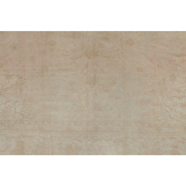 An oversize 2-tone Turkish Oushak carpet in a blonde color tone with pink hues. Very pale and light. Measures: 13'1" x 18'9".