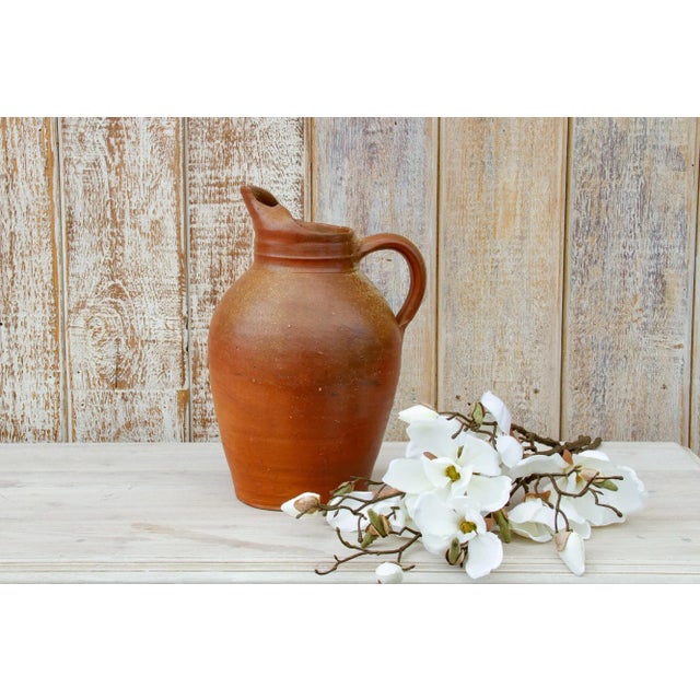 Charming early to mid 20th century clay jug from the Normandy coastline in France. This antique jug was used to store and...