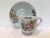 Charming teacup and four matching saucers with delicate gold outlines and hand-applied color. Saucer shapes are ever-so-...