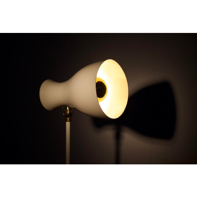 Floor lamp in white lacquered metal and brass, switzerland, 1950s. Electrification checked. Some signs of wear on the base...