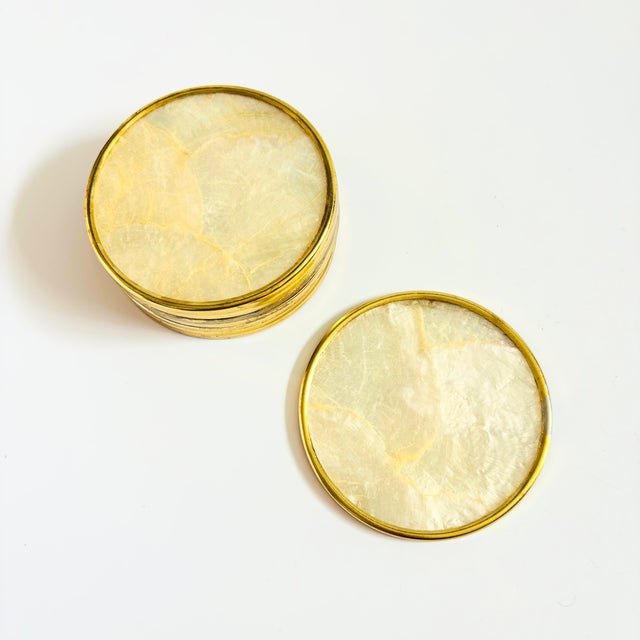 A set of 8 gorgeous vintage capiz shell coasters. Each coaster is trimmed in brass around the edges with natural semi...