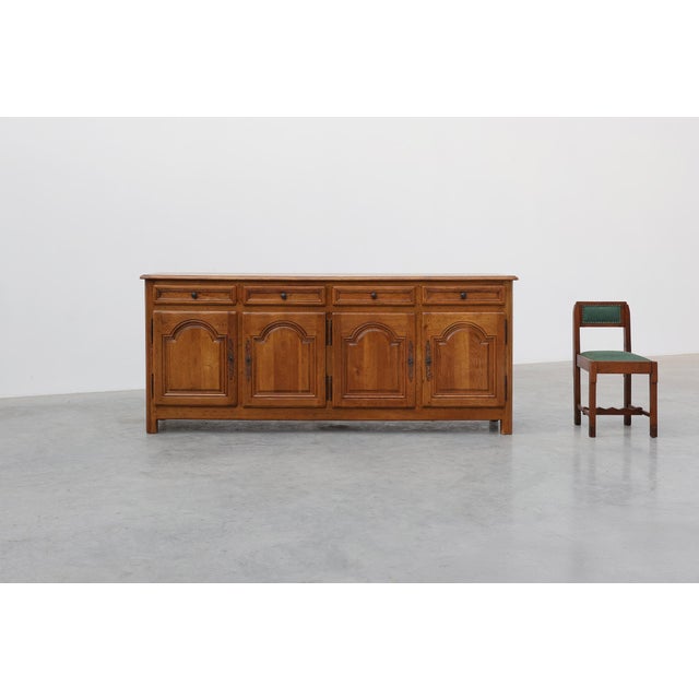 A substantial french oak sideboard by de tonge, distinguished by its architectural façade of four arched raised-panel...