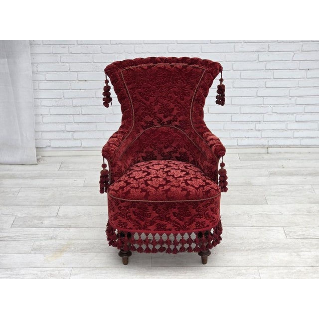 1950s, Danish armchair. Red furniture velour, beech wood legs, brass springs in the seat. The chair was reupholstered by...