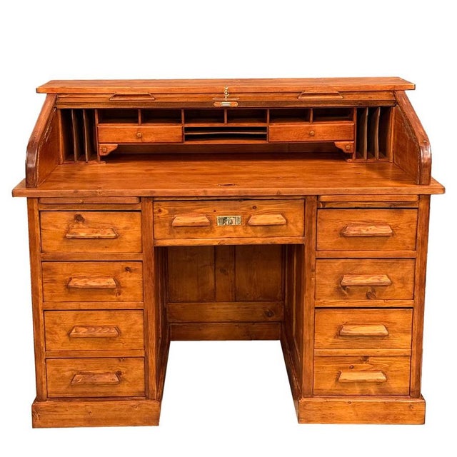 A solid American roll-top desk, notable for its craftsmanship and highly functional design. The interior features numerous...