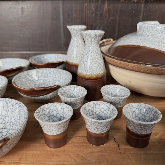 Complete, unused Japanese ceramic set consisting of two sake bottles (tokkuri) with matching holders, five small sake cups...