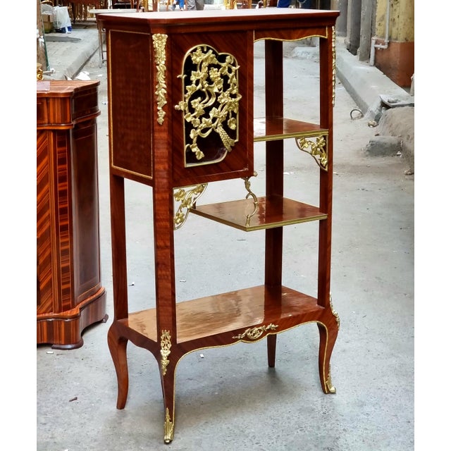 Elegant and refined, this French Louis XVI-style étagère showcases the sophisticated symmetry and decorative craftsmanship...