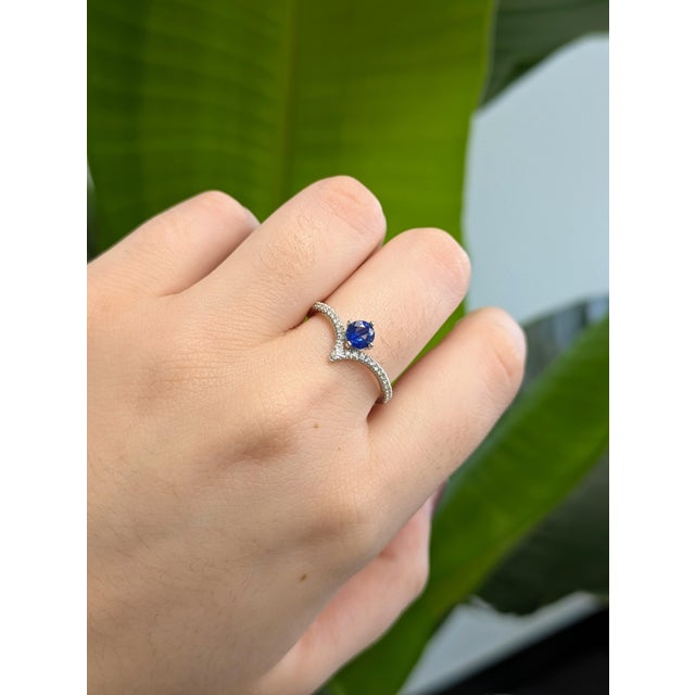 A vibrant blue sapphire takes the spotlight in this modern V-shaped ring, where sleek curves meet radiant sparkle. The...