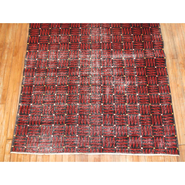 A chic mid-20th century Turkish deco rug with a futurist repetitive design in blacks and red. Age wear.