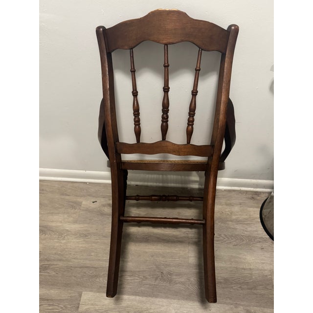 Elegant hand-woven cane chair featuring the hallmarks of late Victorian and Eastlake design, notably the geometric,...