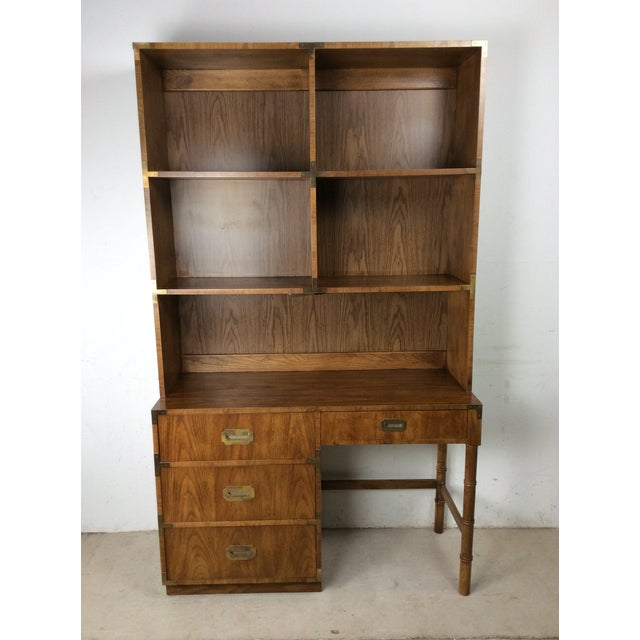 This mid century campaign style writing desk with mounted lighted bookcase from the Campaigner line by Dixie Furniture...