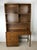 This mid century campaign style writing desk with mounted lighted bookcase from the Campaigner line by Dixie Furniture...