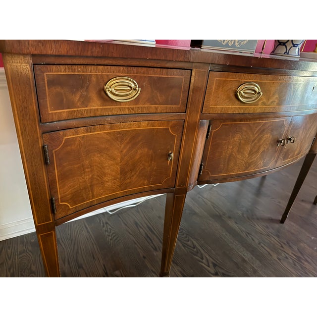 Wellington Hall Limited bow-front Sideboard with Gallery Rail in mahogany with banded detail and brass hardware. Feautures...