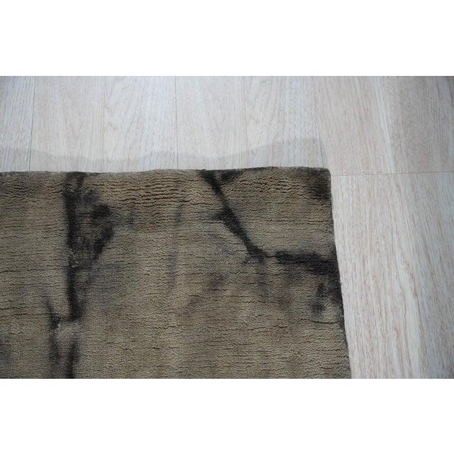 This gray wool rug functions as a durable floor covering featuring a traditional hand knotted pile weave. Designed in the...