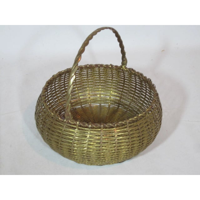 This is a round bombay shaped, solid brass woven basket with swing handle.