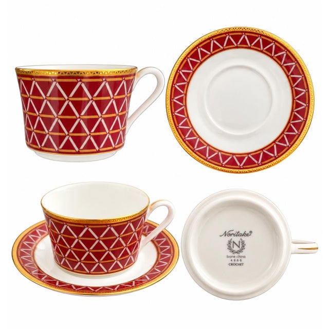 A striking set of four Noritake Crochet bone china tea cups with matching saucers. Featuring a rich crimson-red geometric...