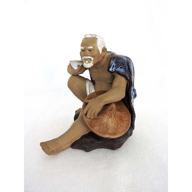 1980's fine Shiwan figure of an elderly white haired man perched on a rock with his wicker hat and drinking cup - probably...