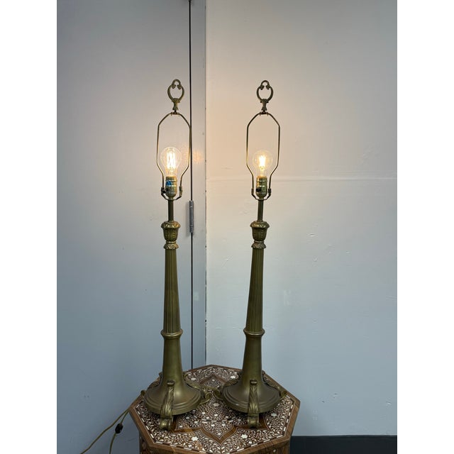 Design Plus Gallery presents a Pair of Vintage Brass Table Lamps. This matched pair showcases antique brass tones with...