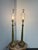 Design Plus Gallery presents a Pair of Vintage Brass Table Lamps. This matched pair showcases antique brass tones with...