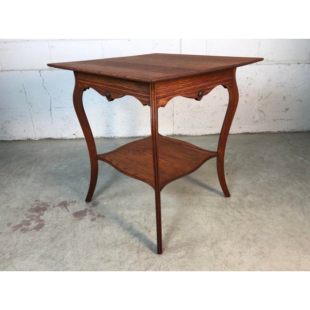 Vintage square quarter-sawn oak two tier plant stand or side table. The table has cabriole style legs with a channeled...
