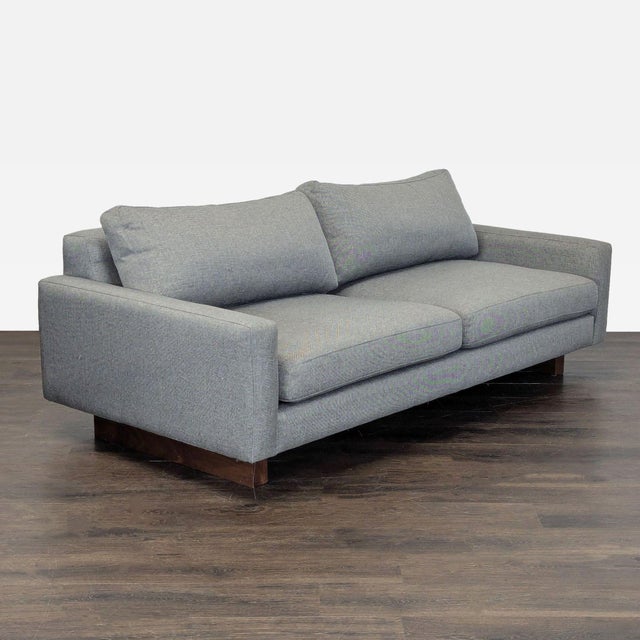 This Room & Board loveseat features a clean, modern design with plush cushions and sturdy wooden legs. The gray fabric is...