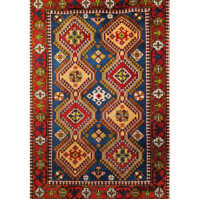 This vibrant vintage Persian Yalameh rug from Southwestern Persia is a striking example of mid-century tribal weaving...