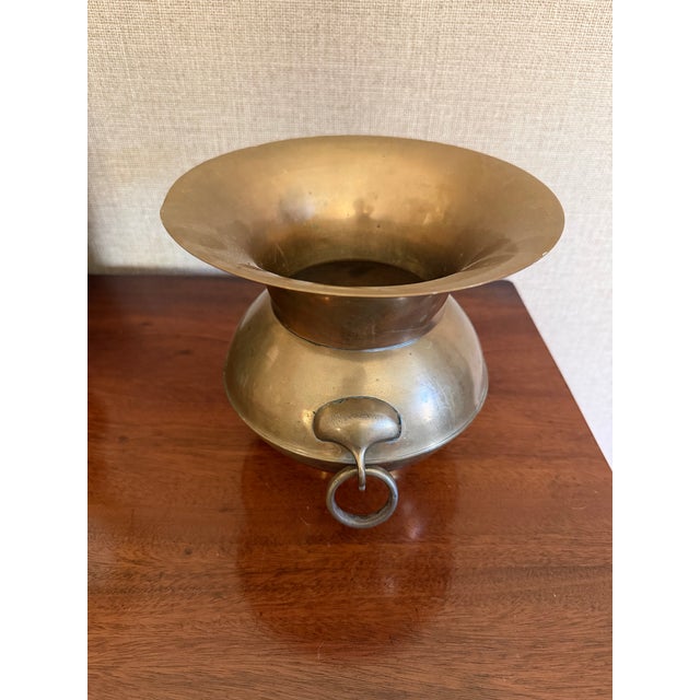This listing is for a vintage solid brass vase with ring handles on two sides. Measures 7 5/8" tall x 6.5" at widest point.