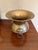 This listing is for a vintage solid brass vase with ring handles on two sides. Measures 7 5/8" tall x 6.5" at widest point.