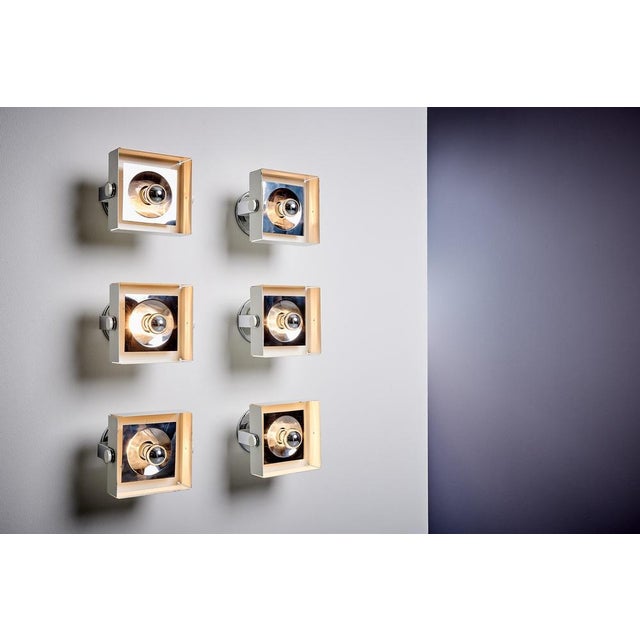 Italian 1960s spotlights, featuring a square, open metal housing with an adjustable reflector. The fixture combines a...