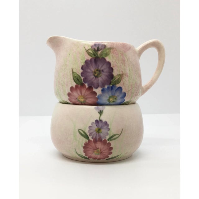 This 2 piece hand painted sugar and creamer set is clearly marked E. Radford, England on the bottom of each piece along...