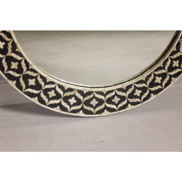 A bone inlay black and white round mirror with floral motifs. This exquisite bone inlay round mirror captures the essence...
