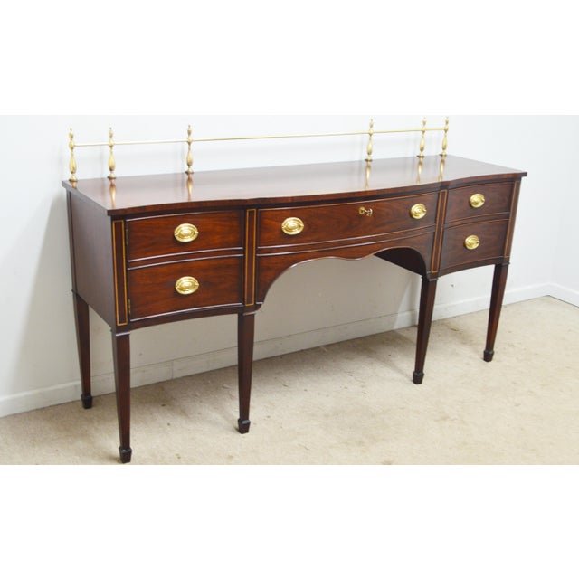 Mahogany Sideboard by Kindel. Store item #546. It features inlaid wood, three drawers and one storage compartment. The...