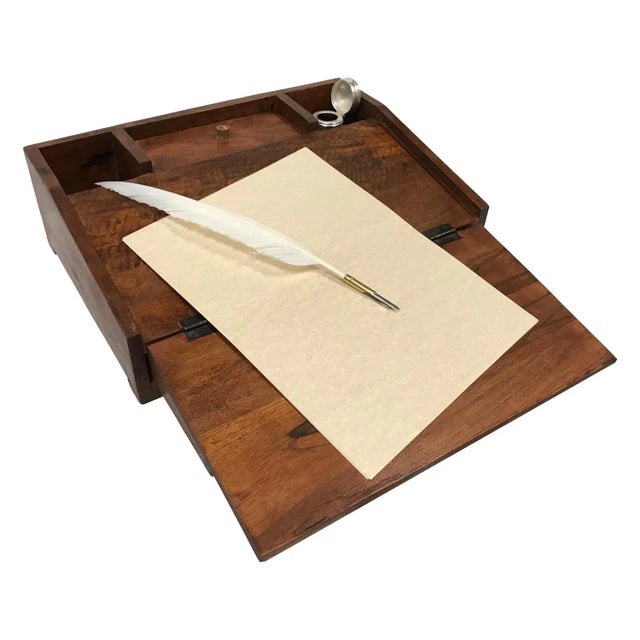 With a two smaller open compartments for ink wells, a larger compartment with lid, a fold out top lid creating the writing...