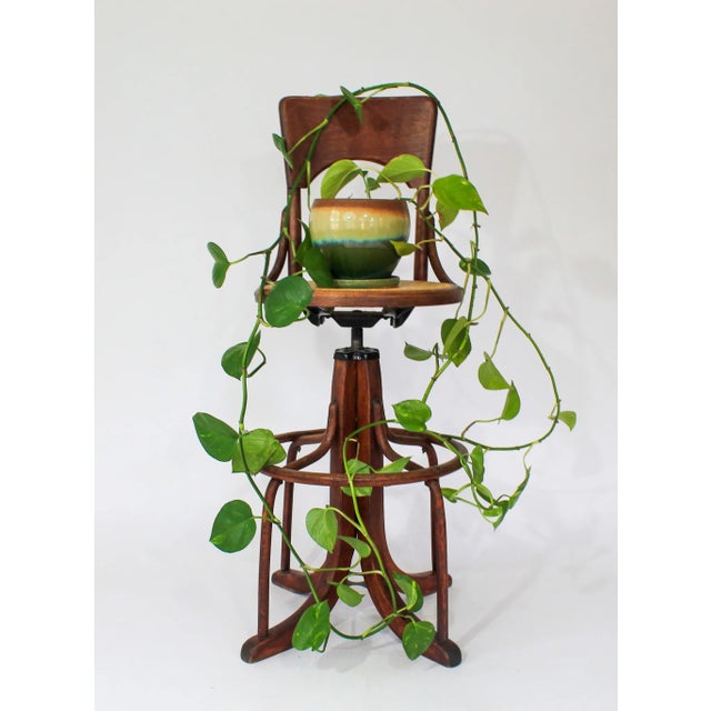 Bentwood and rattan drafting stool with swivel cane seat and solid wood back rest. No makers mark. One older repair to...