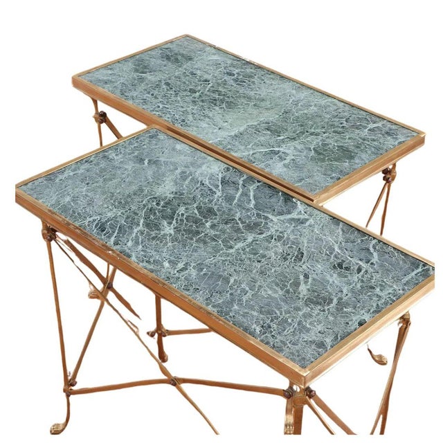A pair of vintage Neoclassical style side tables featuring rectangular green marble tops set within slender brass frames....
