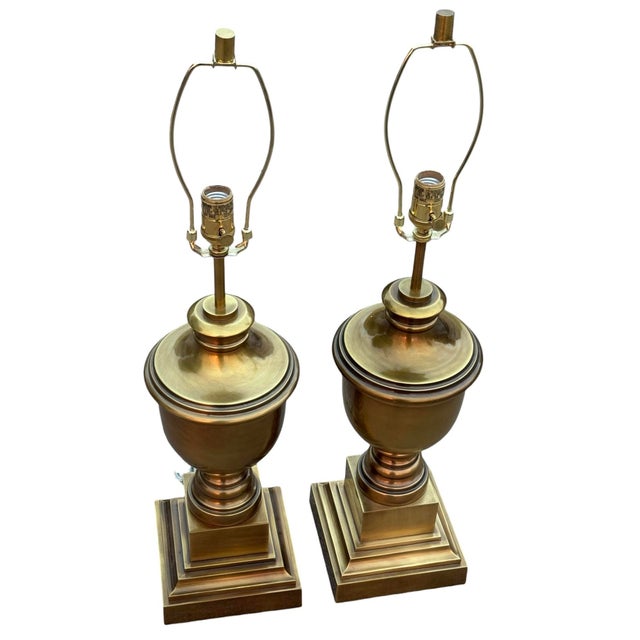 A beautiful pair of brass urn style lamps. Each lamp measures 7 3/8” wide x 7 3/8” deep Height including finial 31 1/2”...