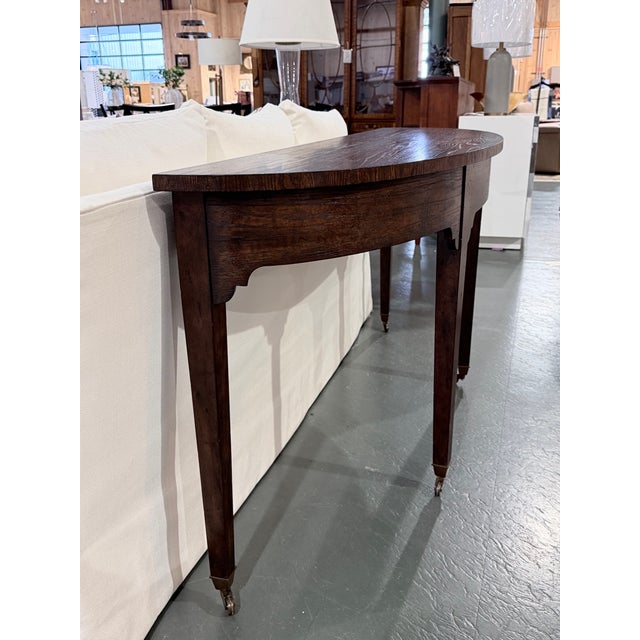 This is a beautifully crafted console table from the Althorp collection by Theodore Alexander, featuring a bow front solid...