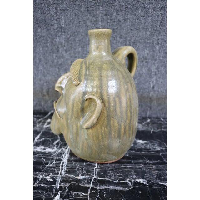 Whimsical terra-cotta glazed, hand made face jug.