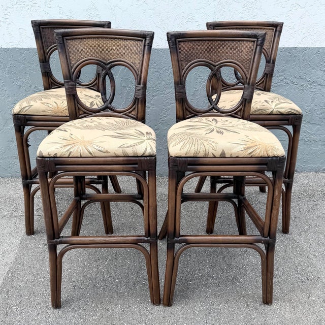 Stylish set of four vintage Boho Chic stools crafted from dark stained rattan with woven wicker accents. Each features an...