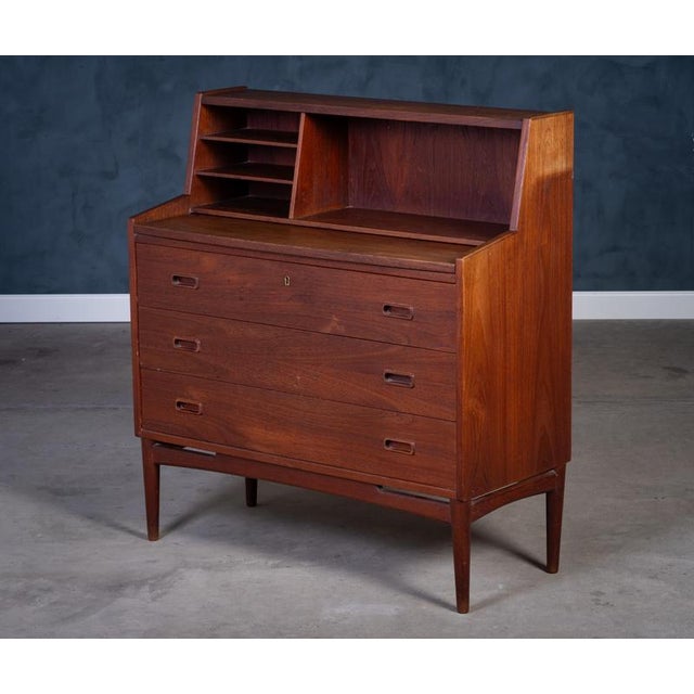 Functional Danish teak secretary / writing desk from the 1960s featuring three spacious drawers and a pull-out writing...