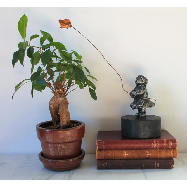 Vintage sculpture of a little girl flying a copper kite on lacquered matte black wood base. No makers mark. Minor age wear.