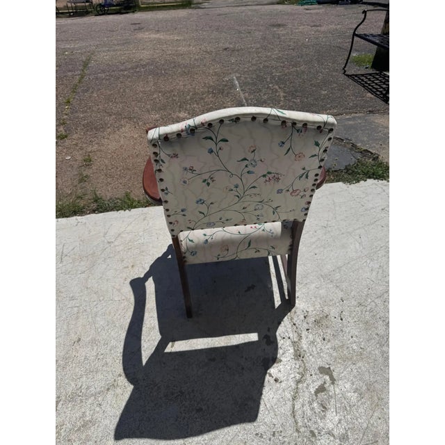 Mid 20th century Spanish revival arm chair. Made from mahogany with flared arms, turned supports and a carved fluer...