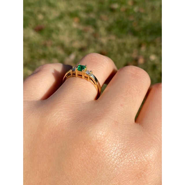 The Tule River: Natural Emerald and Diamond Three Stone Ring in Yellow Gold. At the heart of this elegant ring lies a...