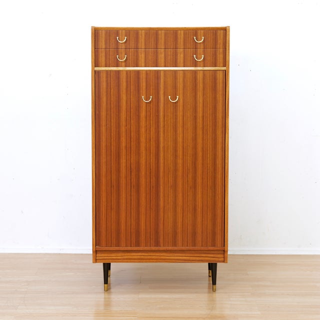 This vintage armoire is a beautiful example of the 'Librenza' produced by E Gomme (G Plan) in the early 1960s. The Tola...