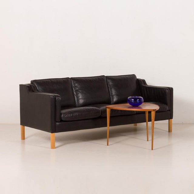 This Stouby black leather sofa, produced in Denmark in the late 1970s or 1980s, is a refined example of late mid-century...