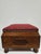 A unique square Victorian style footstool with burgundy upholstered top. This piece has carved wooden appliques to each...