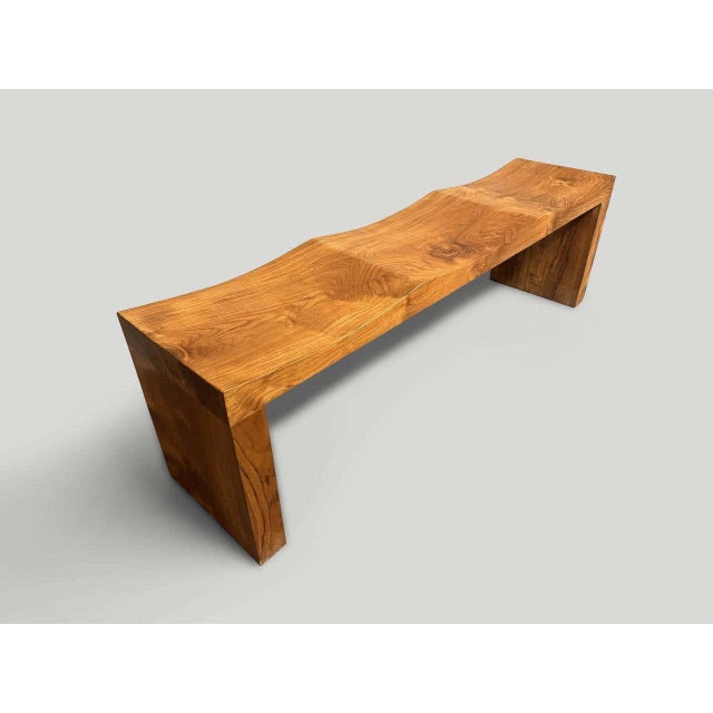 "Minimalist teak wave bench. A solid single slab of ancient teak wood is hand carved into a wave style. Both usable and...