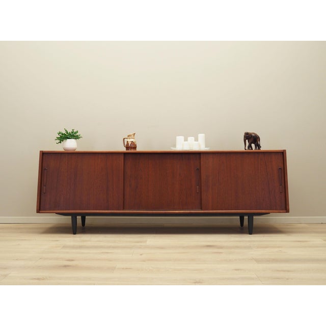 The sideboard was made in the 1970s, Danish production. The structure is covered with teak veneer. The legs are made of...