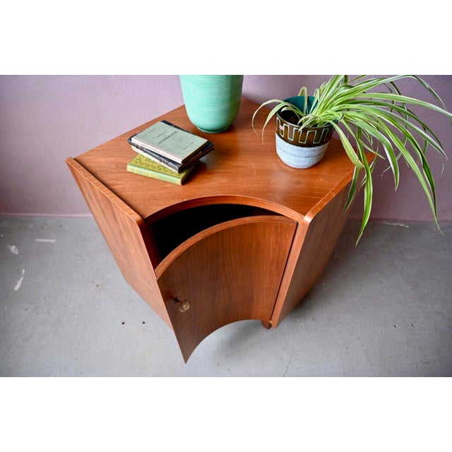 This corner chest of drawers or cabinet dates from the 1960s. Unusual in its shape and design, it features splayed legs...