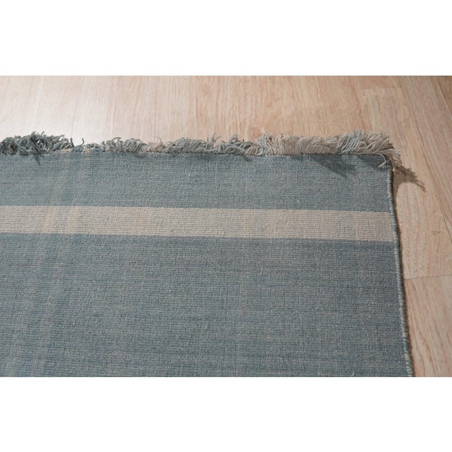 A handwoven wool flatweave, made in India and measuring 8' x 10'. Flatweaves carry no pile, so the geometry is woven...